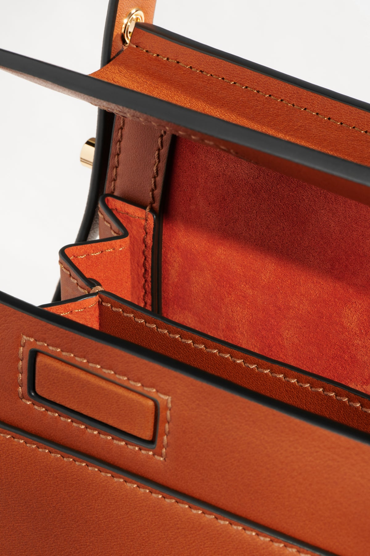 High Rise in Saddle leather with its compartments open, showing the lining and interior pocket